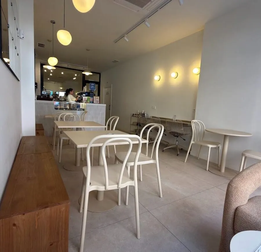 Interior de Nanü con mesas de madera, sillas en tonos crema y luces cálidas